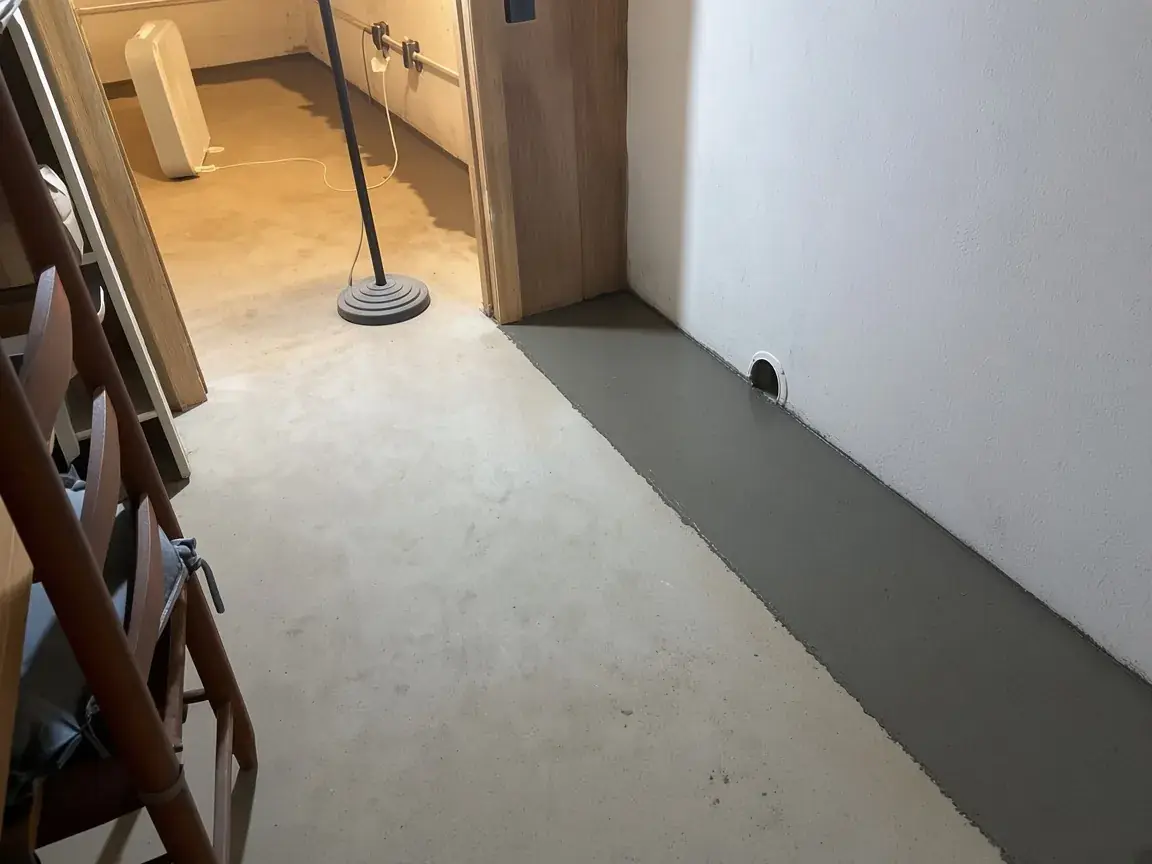 New concrete strip over an interior perimeter drain